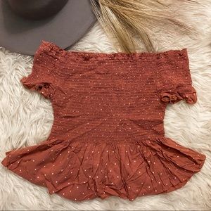 Off-the-shoulder pink polka dot shirt